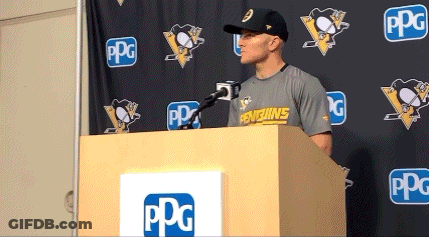 A Man Stands Behind A Podium With A Penguins Shirt On GIF