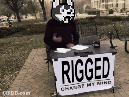 A Man Stands Behind A Sign That Says Rigged Change My Mind GIF