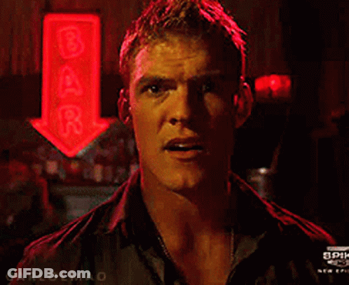 A Man Stands In Front Of A Bar Sign GIF