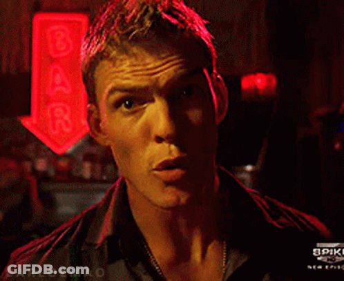 A Man Stands In Front Of A Bar Sign That Says Spike GIF