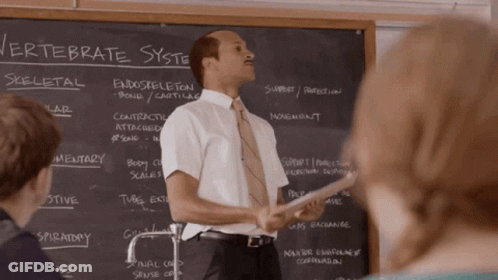 A Man Stands In Front Of A Blackboard With The Word Vertebrate Written On It GIF