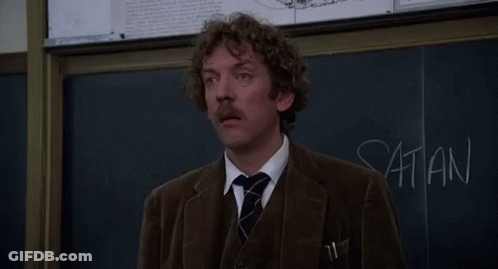 A Man Stands In Front Of A Blackboard With The Words Listen I 'M Not Joking Written On It GIF