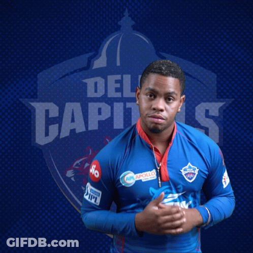 A Man Stands In Front Of A Blue Background With The Word Del Capitals On It GIF