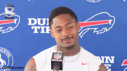 A Man Stands In Front Of A Buffalo Bills Banner GIF