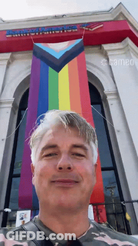 A Man Stands In Front Of A Building That Says Armored America On It GIF