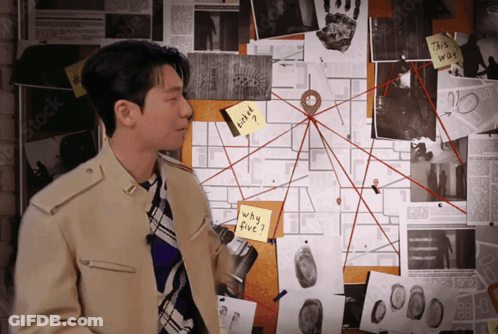 A Man Stands In Front Of A Bulletin Board With A Sticky Note On It That Says " Why Five " GIF
