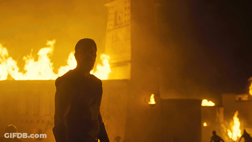 A Man Stands In Front Of A Burning Building With The Number 1 On It GIF