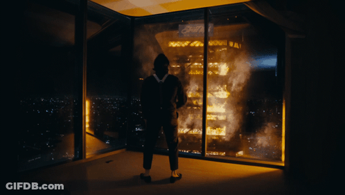 A Man Stands In Front Of A Burning Building With The Word Ford On The Top GIF