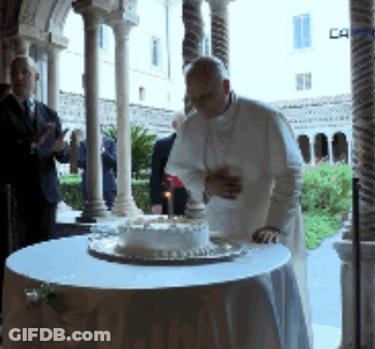 A Man Stands In Front Of A Cake With A Candle On It GIF