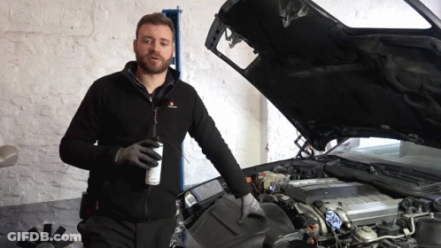 A Man Stands In Front Of A Car With Its Hood Open GIF