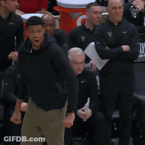 A Man Stands In Front Of A Chair That Says Playoffs GIF
