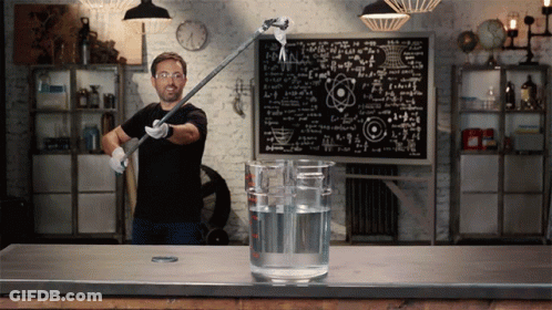 A Man Stands In Front Of A Chalkboard With Equations GIF