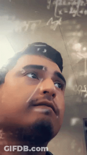 A Man Stands In Front Of A Chalkboard With Math Equations Written On It GIF