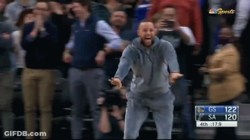 A Man Stands In Front Of A Crowd At A Basketball Game With A Score Of 120 To Gs GIF