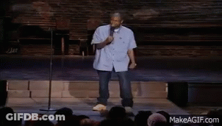 A Man Stands In Front Of A Crowd Holding A Microphone And Dancing GIF