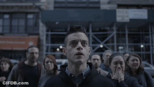 A Man Stands In Front Of A Crowd Looking Up GIF
