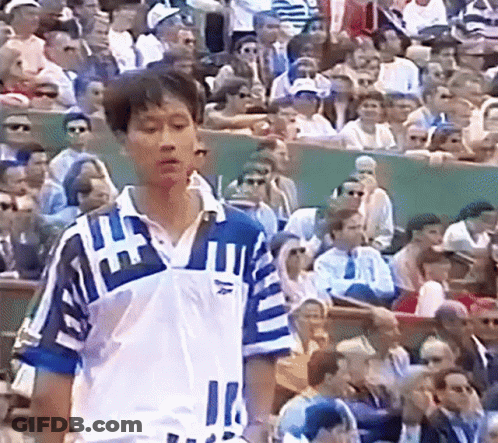 A Man Stands In Front Of A Crowd Wearing A Blue And White Shirt With The Number 11 On It GIF