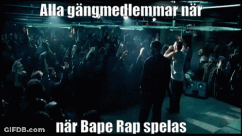 A Man Stands In Front Of A Crowd With The Words Alla Gangmedlemmarnar Near Bape Rap Spelas Below Him GIF