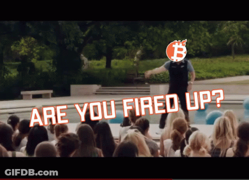 A Man Stands In Front Of A Crowd With The Words " Are You Fired Up " Above Him GIF