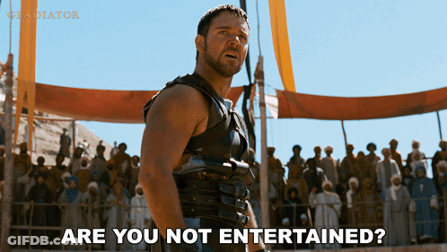 A Man Stands In Front Of A Crowd With The Words Are You Not Entertained GIF