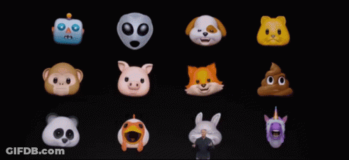 A Man Stands In Front Of A Display Of Cartoon Faces GIF