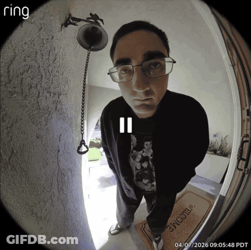 A Man Stands In Front Of A Door With A Welcome Mat GIF