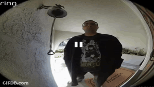 A Man Stands In Front Of A Door With A Welcome Mat GIF
