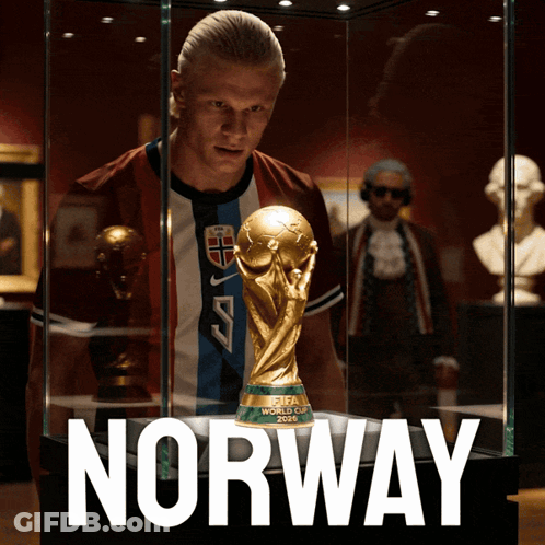 A Man Stands In Front Of A Fifa World Cup Trophy In A Glass Case GIF