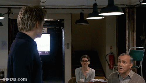 A Man Stands In Front Of A Fire Extinguisher In A Room GIF