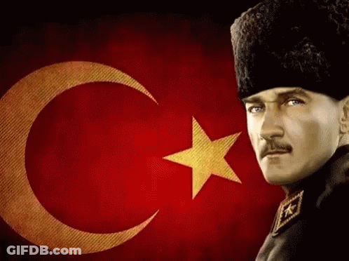 A Man Stands In Front Of A Flag With A Crescent Moon And Star GIF