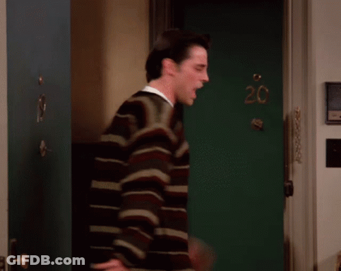 A Man Stands In Front Of A Green Door With The Number 20 Written On It GIF