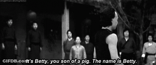 A Man Stands In Front Of A Group Of People And Says " It 'S Betty You Son Of A Pig " GIF