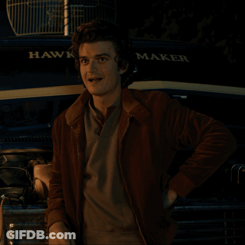 A Man Stands In Front Of A Hawk Maker Vehicle GIF