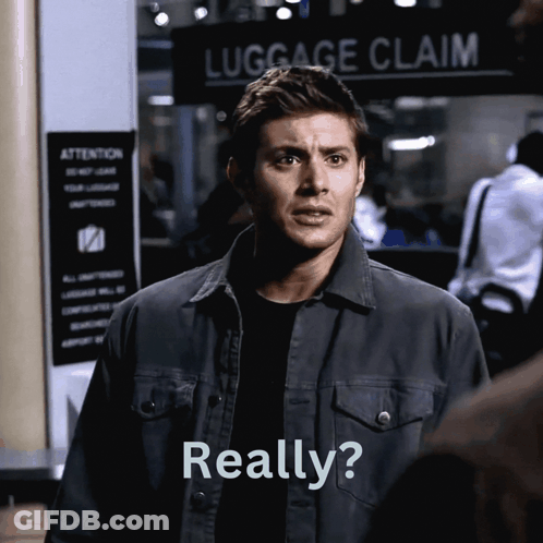 A Man Stands In Front Of A Luggage Claim Sign And Says Really GIF