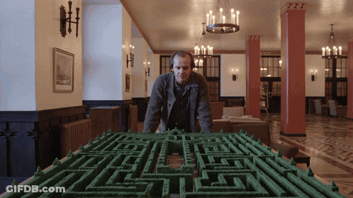 A Man Stands In Front Of A Maze With The Letters Zzz On The Ceiling GIF