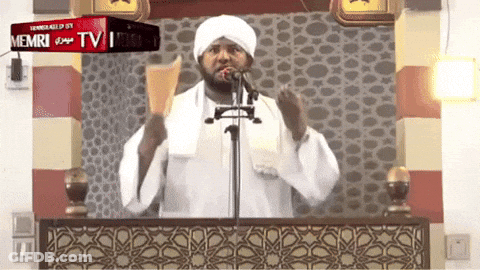 A Man Stands In Front Of A Microphone And A Sign That Says Memri Tv On It GIF