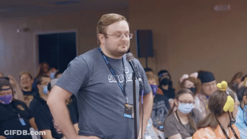 A Man Stands In Front Of A Microphone Wearing A Shirt That Says Sdue GIF