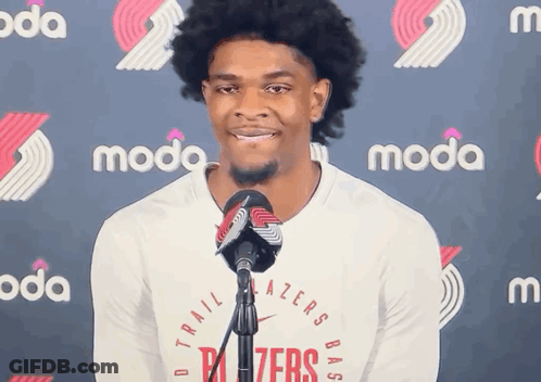 A Man Stands In Front Of A Microphone Wearing A Trailblazers Shirt GIF