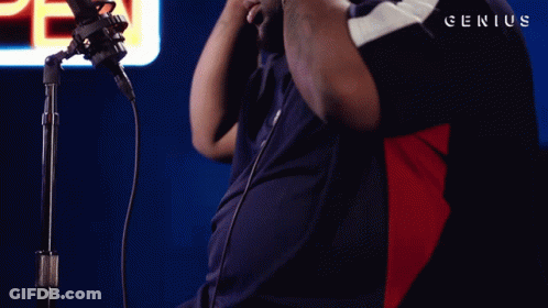 A Man Stands In Front Of A Microphone With Genius Written On The Bottom Right GIF