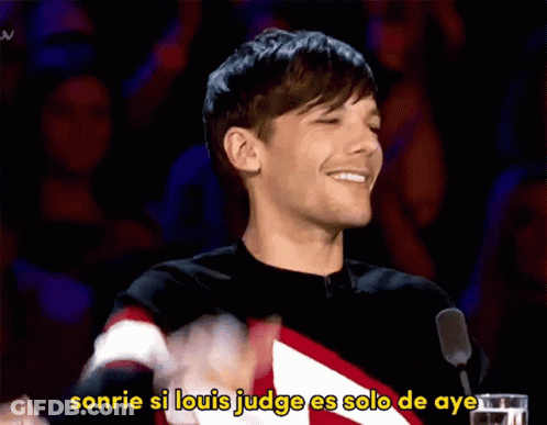 A Man Stands In Front Of A Microphone With The Words Sonrie Si Louis Judge Es Solo De Aye Written Below Him GIF