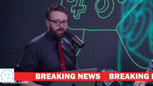 A Man Stands In Front Of A Microphone With The Words We Have Breaking Above Him GIF