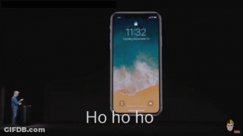 A Man Stands In Front Of A Phone That Says 11:32 On The Screen GIF