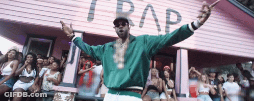 A Man Stands In Front Of A Pink Building That Says Trap On It GIF