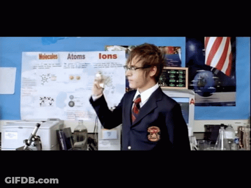 A Man Stands In Front Of A Poster About Molecules And Atoms GIF