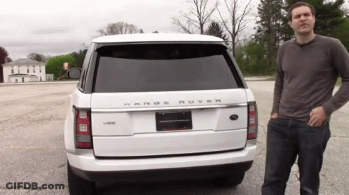 A Man Stands In Front Of A Range Rover GIF