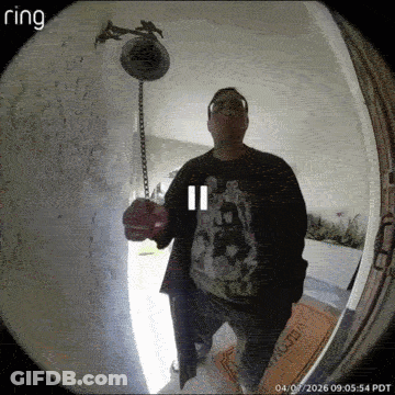 A Man Stands In Front Of A Ring Doorbell Holding A Bell GIF