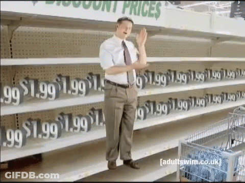 A Man Stands In Front Of A Row Of Empty Shelves That Say 1.99 GIF