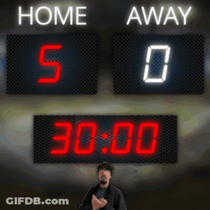 A Man Stands In Front Of A Scoreboard That Reads Home 5-0 Away 0 GIF