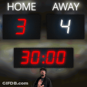 A Man Stands In Front Of A Scoreboard That Says Home 34 Away 22 30 GIF
