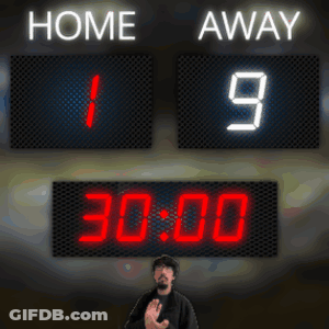 A Man Stands In Front Of A Scoreboard Which Says Home And Away GIF